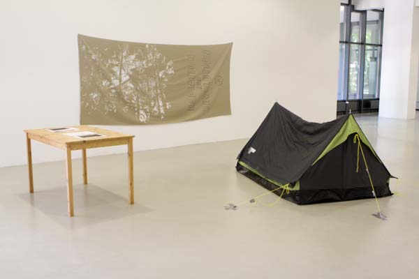  a Tent and table with a banner on wall